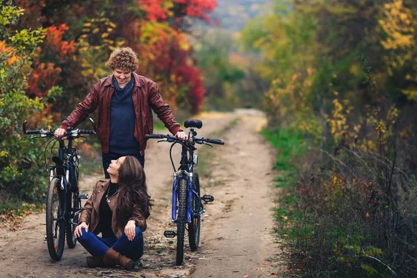 Кудрявый Усатый Парень Рыжеволосая Девушка Осенью Стоят Велосипедами Дороге Показывают — стоковое фото