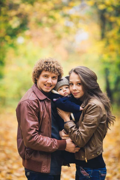 Young family hugging in autumn in park. — Stock Photo, Image