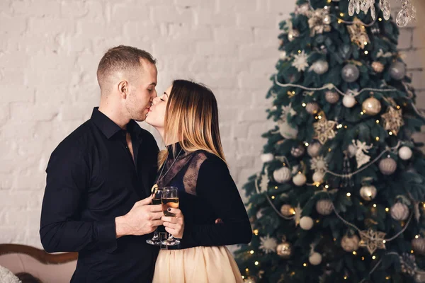 Любящая пара в стильной одежде с бокалами вина на Рождество . — стоковое фото