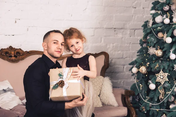 Батько дає його дочка Різдвяний подарунок і охоплює її. — стокове фото