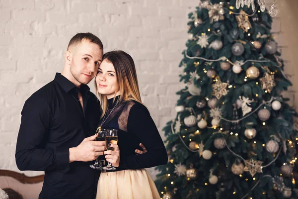 Couple aimant dans des vêtements élégants avec des verres de vin à Noël . — Photo