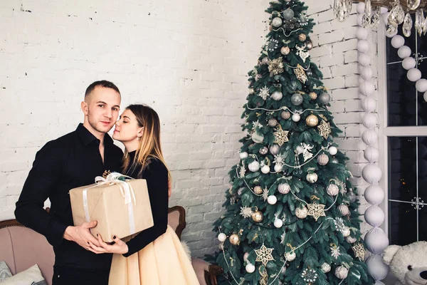 Любляча пара тримає різдвяний подарунок в декорованій кімнаті . — стокове фото