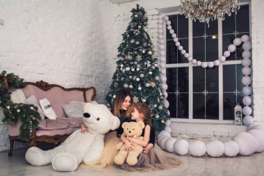 Mutlu anne ve kızı oyuncak ayılar Noel arifesinde tutuyorsun.