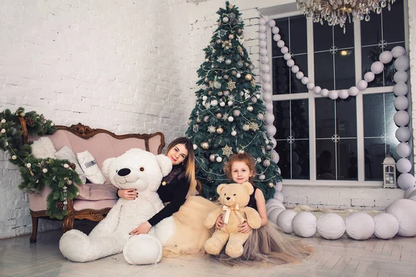 Feliz madre e hija están sosteniendo osos de peluche en Nochebuena . — Foto de Stock