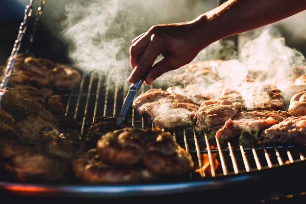 Meat and sausages are fried on large grill in street cafe. — Stock Photo, Image