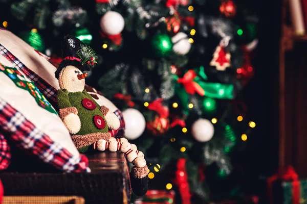 Christmas speelgoed elf zittend op koffer op de achtergrond van de kerstboom. — Stockfoto