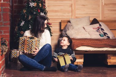 Anne ve oğlu katta oturan ve Noel tutarak sunar.