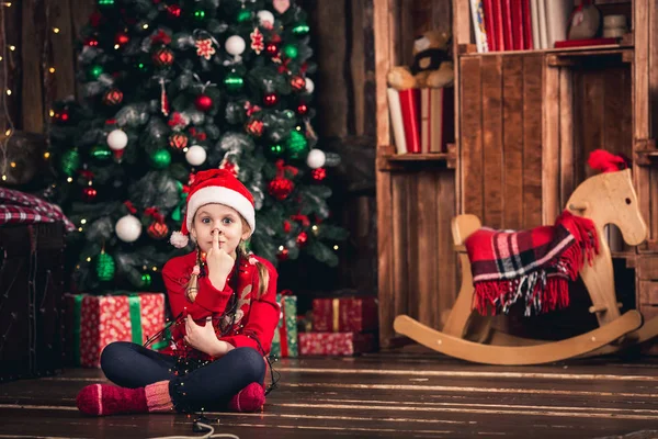 Santa meisje verpakt in garland en toont neus varken. — Stockfoto