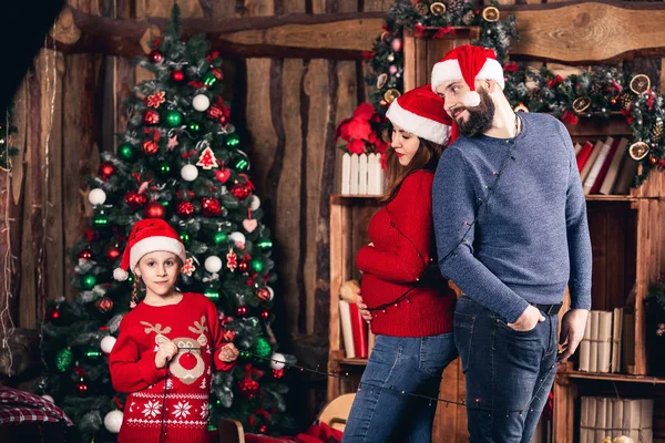 Santa meisje terugloopt vrolijk haar ouders met garland. — Stockfoto