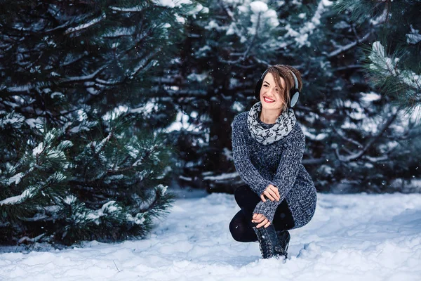 Stylish cheerful girl in a sweater in the winter forest. — Stock Photo, Image