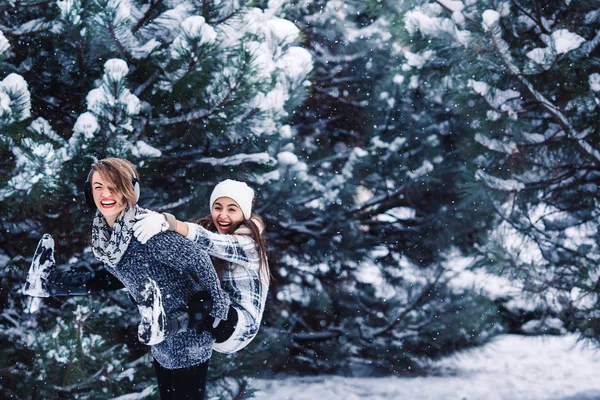 Moeder en dochter hebben plezier spelen in het bos van de winter. — Stockfoto