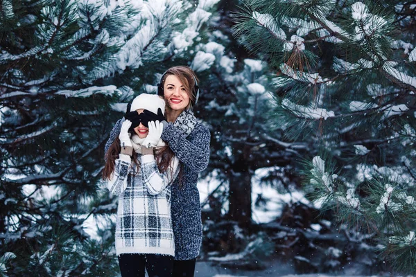 Mother and daughter have fun playing in the winter forest. — Stock Photo, Image