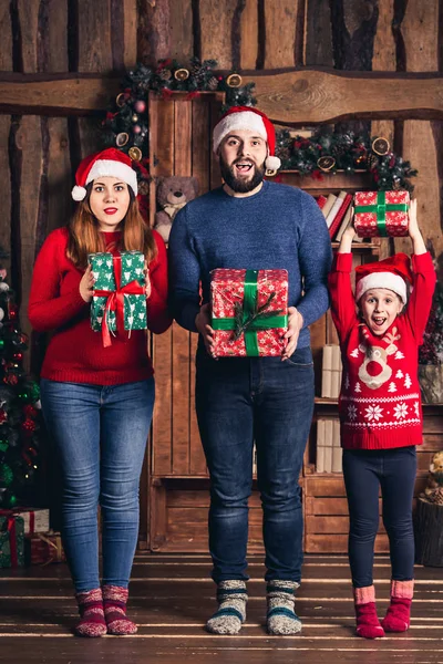 Vrolijke gezin met giften in hun handen voor Kerstmis. — Stockfoto