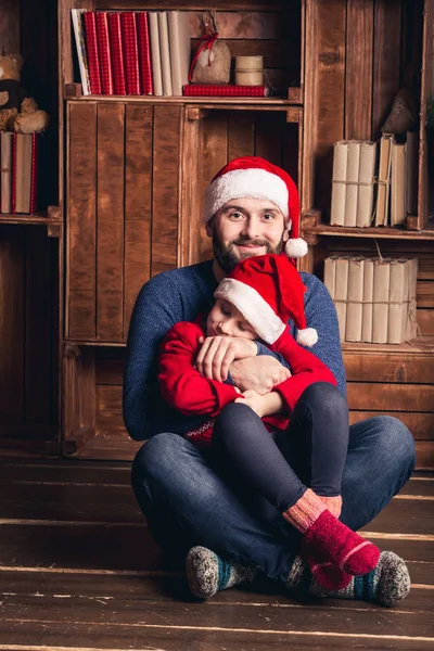 Vader en dochter zijn zittend op de vloer omarmen en wachten voor Kerstmis. — Stockfoto