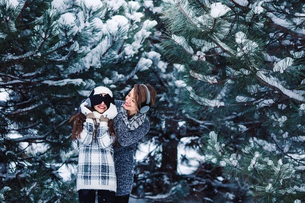 Mother and daughter have fun playing in the winter forest. — Stock Photo, Image