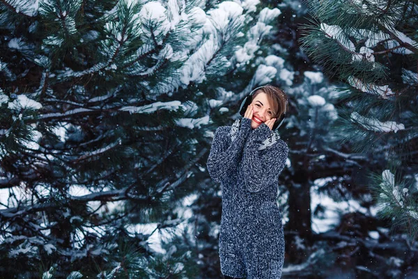 Stylish cheerful girl in a sweater in the winter forest. — Stock Photo, Image