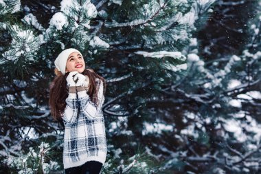 Bir kazak kış ormandaki şık neşeli kız.