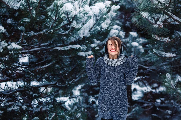 Stylish cheerful girl in a sweater in the winter forest. — Stock Photo, Image