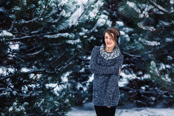 Stylish cheerful girl in a sweater in the winter forest. — Stock Photo, Image