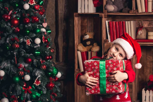 Gelukkig meisje met genegenheid houdt een kerstcadeau in haar handen. — Stockfoto