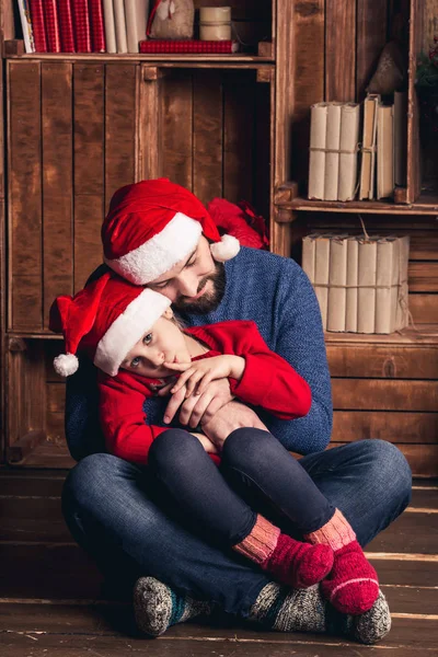 Vader en dochter zijn zittend op de vloer omarmen en wachten voor Kerstmis. — Stockfoto