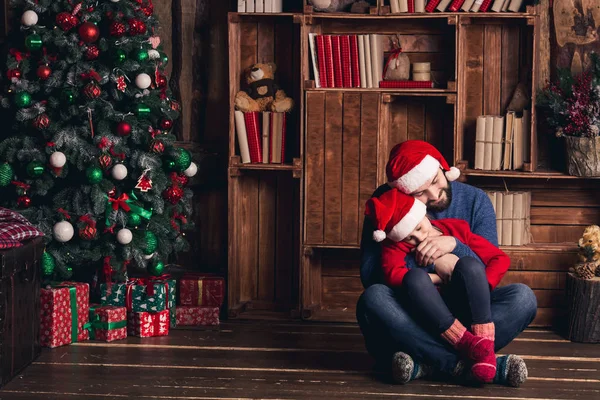 Vader en dochter zijn zittend op de vloer omarmen en wachten voor Kerstmis. — Stockfoto