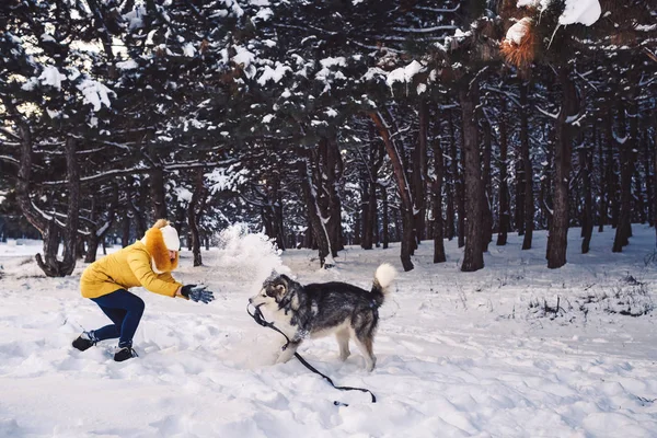 Mooi jong meisje grappige spelen met haar hond in de winter in park — Stockfoto