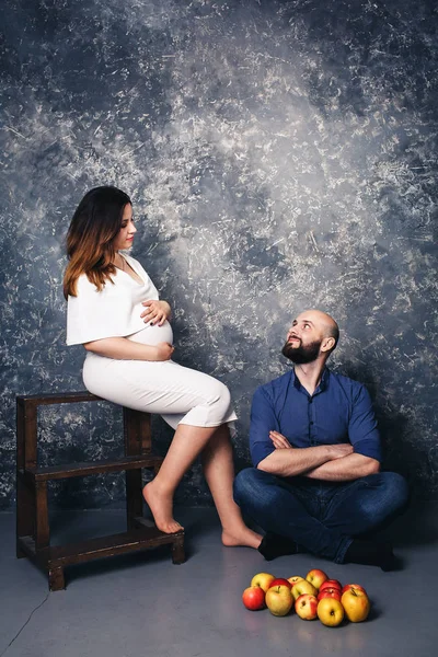 Jovem casal grávida e maçãs no chão. conceito doce vida familiar . — Fotografia de Stock