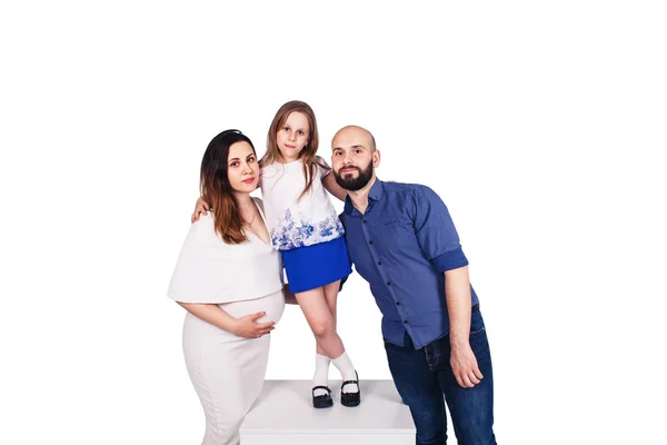 Mladá rodina izolované na bílém pozadí. Těhotné matky, vousatá otec a dcera objímat. — Stock fotografie