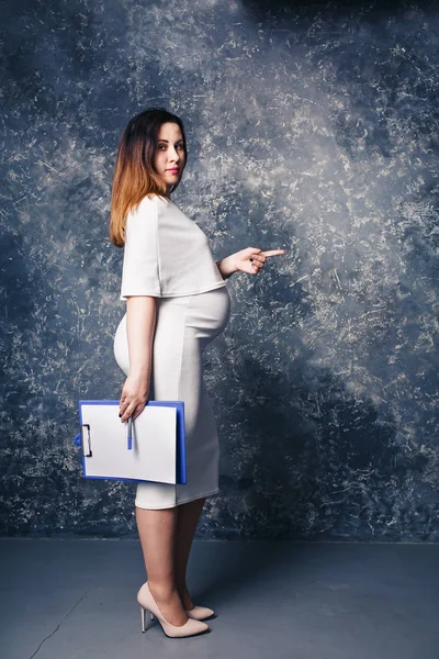 Красивая молодая беременная деловая женщина показывает копирайт пальцев . — стоковое фото