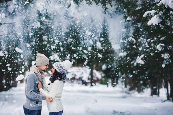 Man and girl in sweaters hugging in the park in winter. winter walk, rest. — Stock Photo, Image