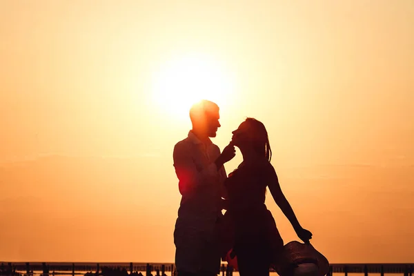 Silueta imagen de una pareja amorosa abrazándose al atardecer en un lago . —  Fotos de Stock