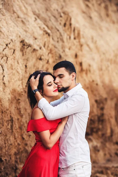 Красива жінка і бородатий чоловік обіймається біля глиняної скелі . — стокове фото