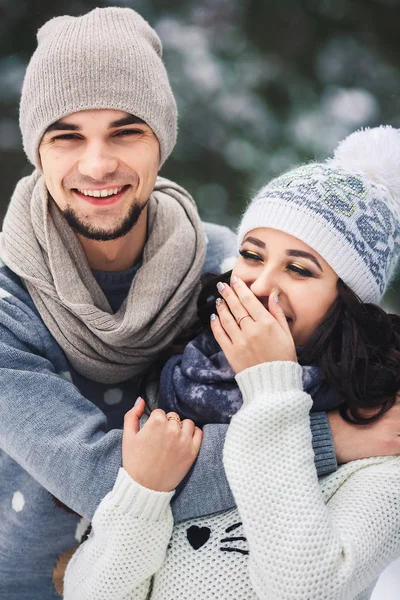 Мужчина и девушка в свитерах обнимаются в парке зимой. зимняя прогулка, отдых . — стоковое фото