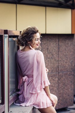 yanında güzel bir yapı poz kısa pembe elbiseli çekici genç kız.