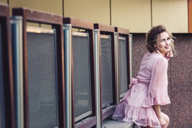 yanında güzel bir yapı poz kısa pembe elbiseli çekici genç kız.