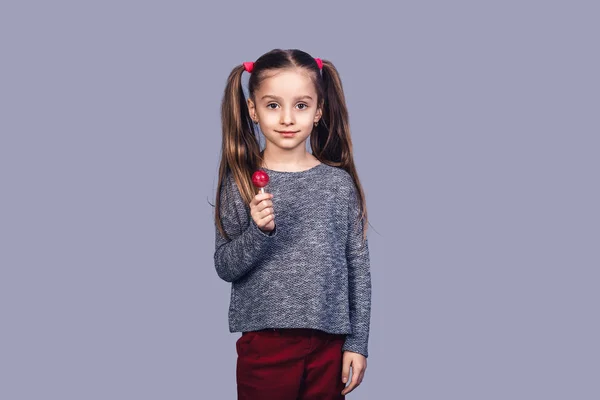 Schattig meisje houdt van een rode lolly. — Stockfoto