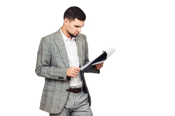 Jonge stijlvolle man in een grijs pak met een tablet in zijn hand. — Stockfoto