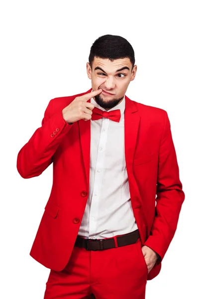 Killen har något fastnat i tänderna. rolig man i röd kostym visar ett finger i munnen — Stockfoto