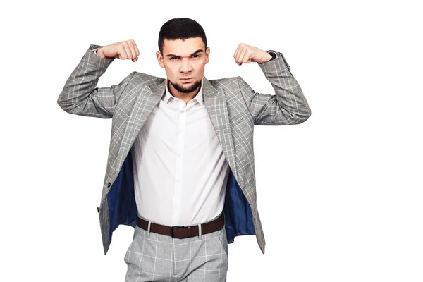 Hombre de negocios seguro de sí mismo. Elegante joven barbudo en un traje gris muestra sus bíceps —  Fotos de Stock