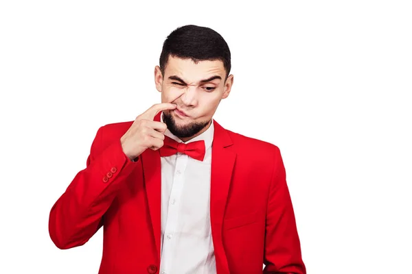 Hombre divertido en un traje rojo muestra un dedo en su boca —  Fotos de Stock