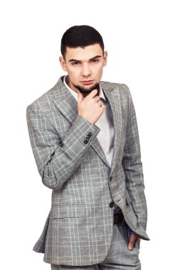 beyaz bir arka plan üzerinde poz bir gri takım elbiseli adam şık genç sakallı.