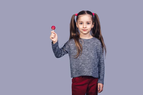 Schattig Meisje Houdt Van Een Rode Lolly Geïsoleerd Een Grijze — Stockfoto