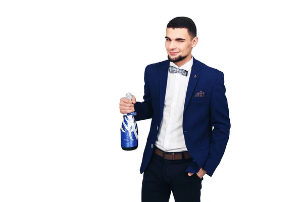 Joven hombre elegante en un traje azul con una botella decorada de champán o vino — Foto de Stock