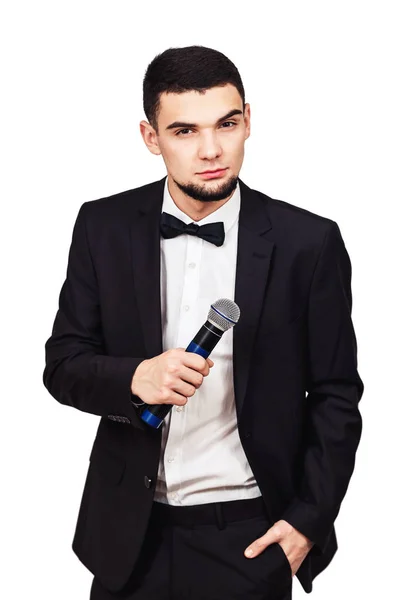 Elegante homem elegante em um terno preto com um microfone em sua mão — Fotografia de Stock