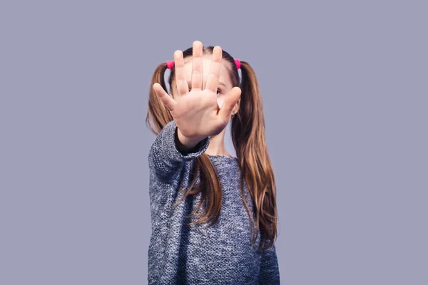 Verdrietig meisje toont hand stopbord. Concept stop kindermisbruik. — Stockfoto