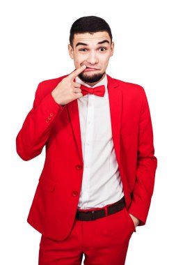 adamın dişlerini içinde sıkışmış bir şey var. komik adam kırmızı elbiseli bir parmağını ağzına gösterir.