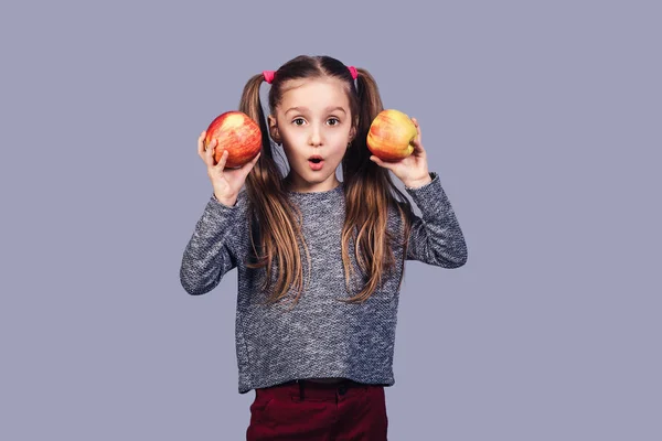 Schattig Meisje Houdt Twee Appels Haar Handen Toont Een Verbaasd — Stockfoto