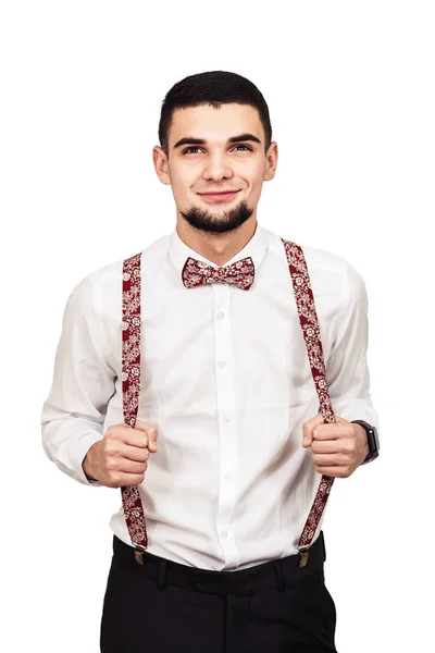 Elegante ragazzo barbuto in camicia, pantaloni e bretelle in posa su uno sfondo bianco — Foto Stock