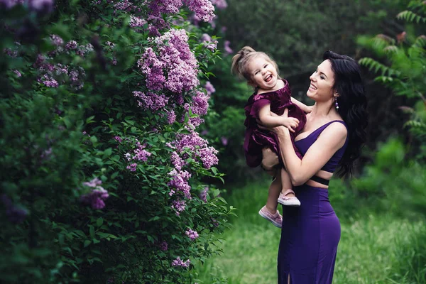 Madre Alegre Hija Pequeña Vestidos Púrpura Jugando Naturaleza Cerca Floreciente — Foto de Stock